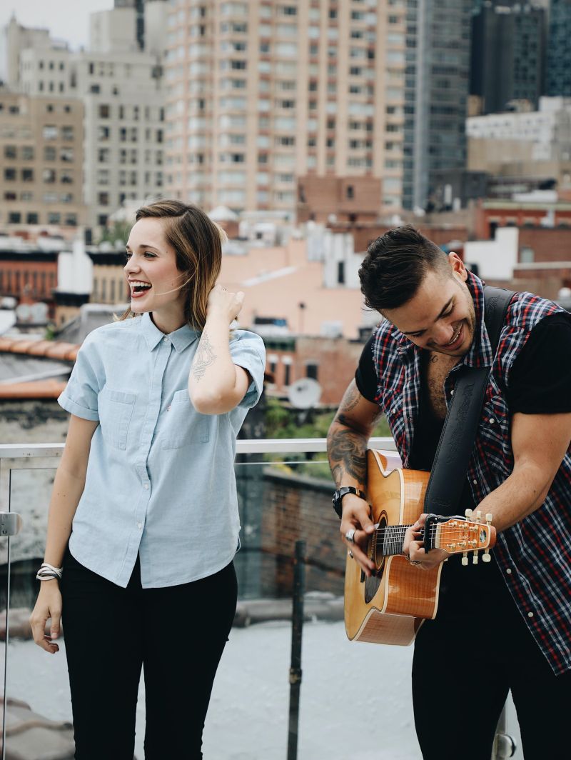 man singing love son that he wrote to woman on rooftop